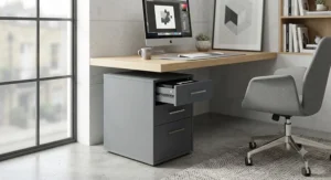 Contemporary slate grey wooden 3 drawer pedestal with brushed steel handles styled in a contemporary workspace
